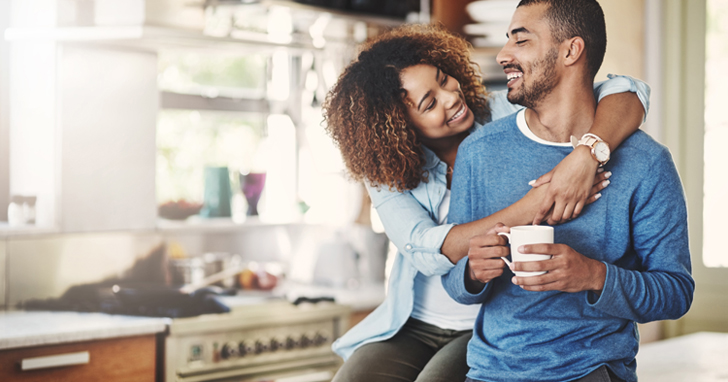 African-American couple drinking coffee in kitchen