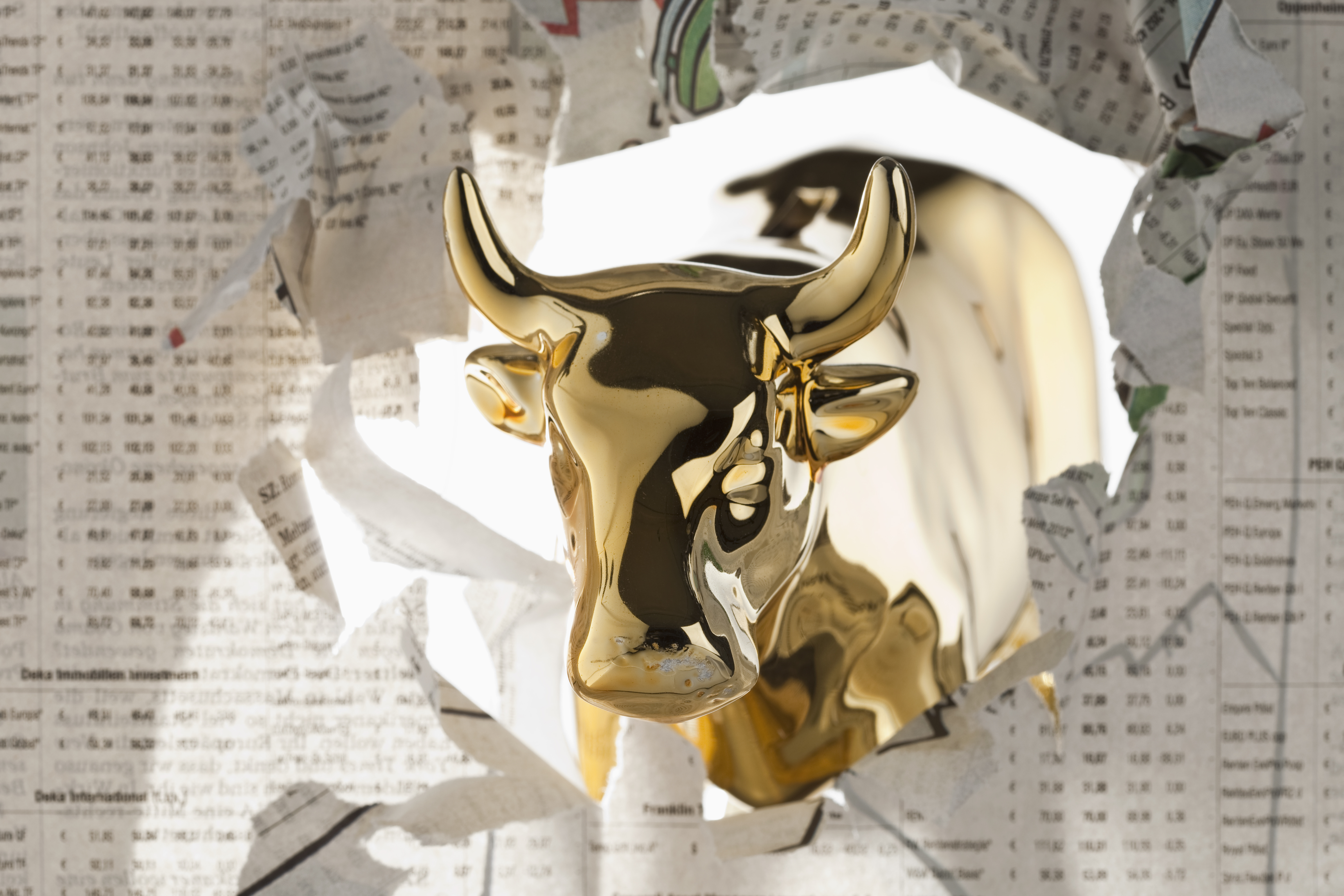 golden bull statue breaks through stock report newspaper