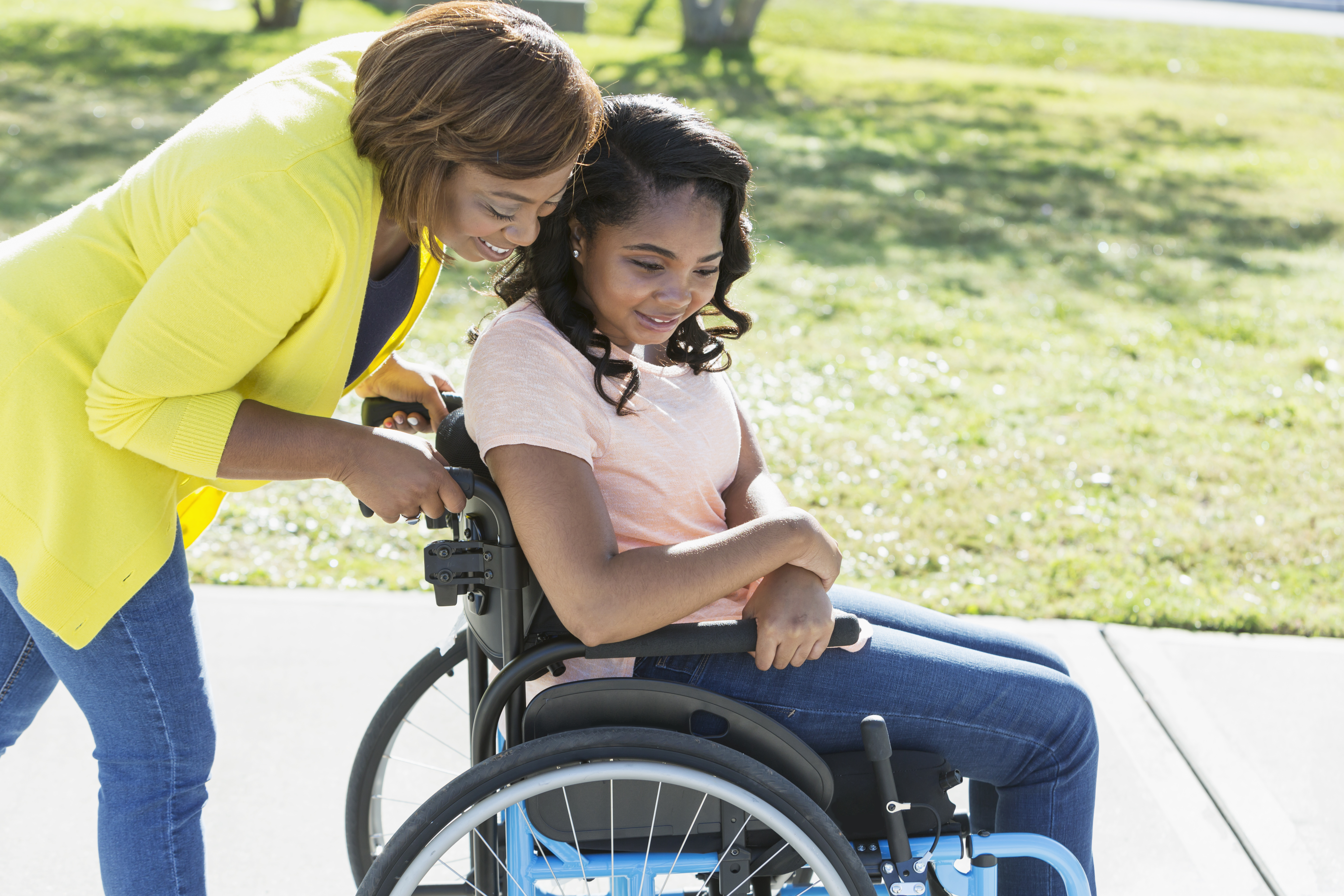 mother pushes teenage daughter in wheelchair