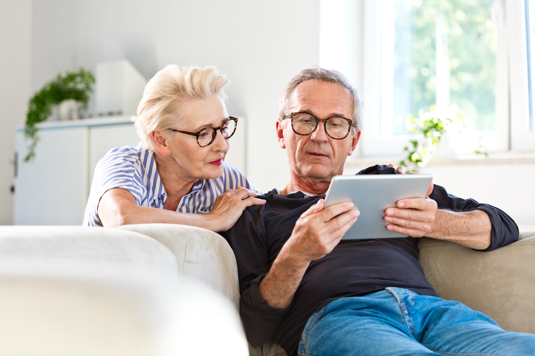 couple uses tablet to monitor investments