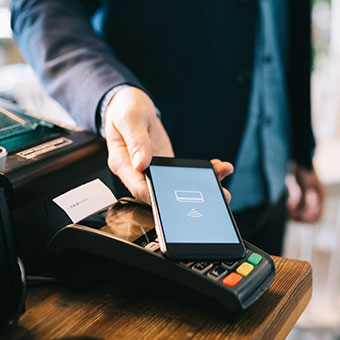 man uses phone to pay at store